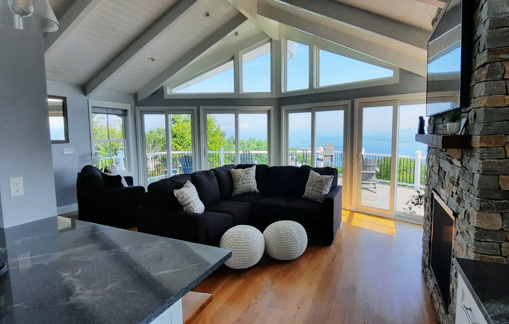 A picture of a living room with a black couch and a fireplace